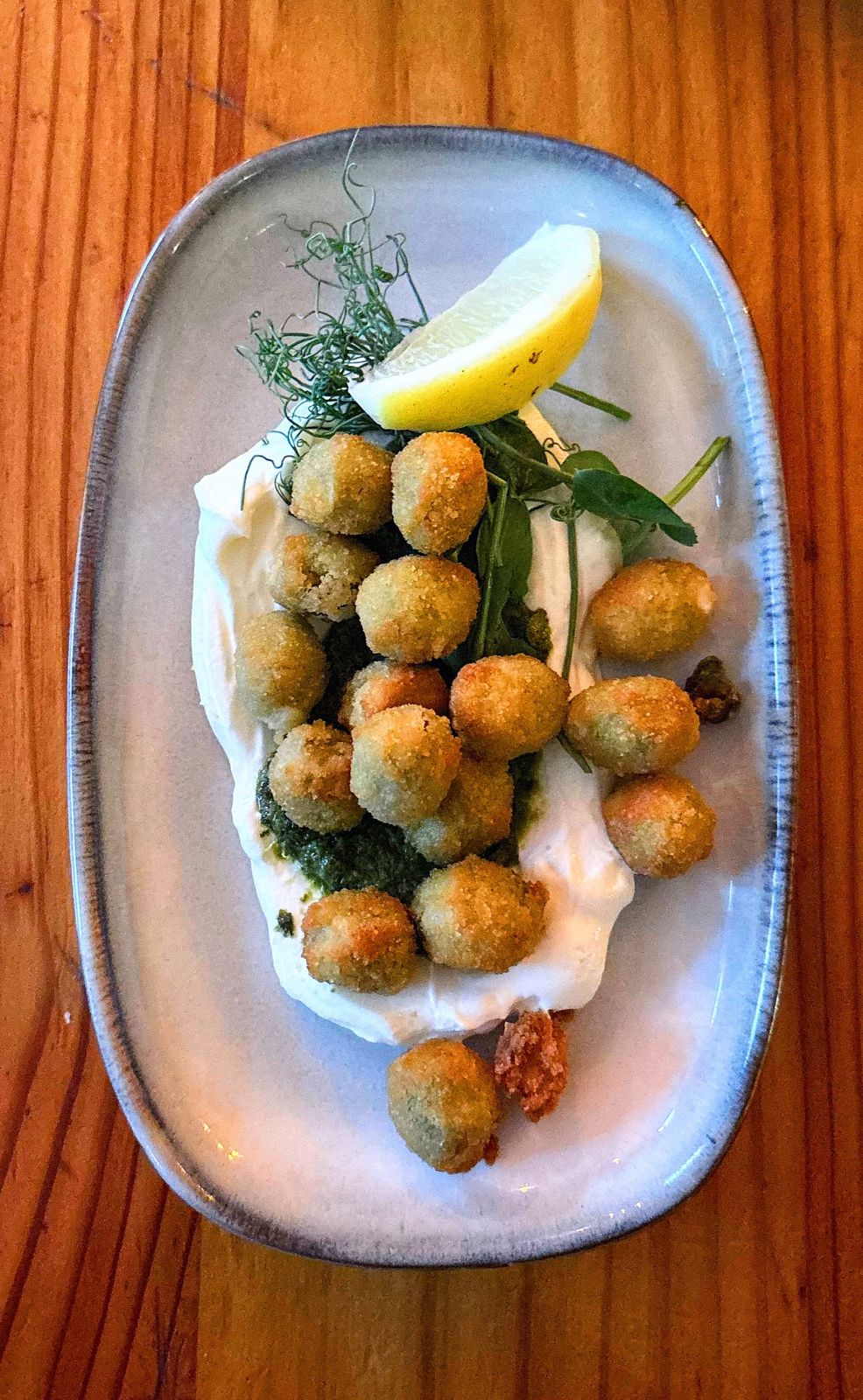 Olives panées servies avec labneh et sauce aux herbes
